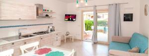 a kitchen with a couch and a table in a room at Mediterranean Sea Shell Pool House in Budoni
