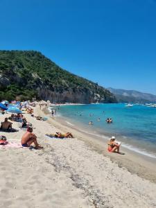 a group of people laying on a beach at Mediterranean Sea Shell Pool House in Budoni
