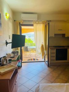 a room with a kitchen with a door to a patio at New Orange Studio 9 in Budoni