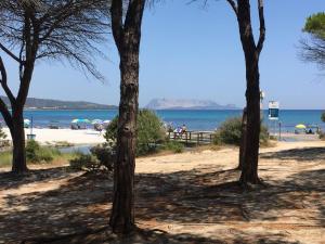 a view of a beach with people on the beach at New Orange Studio 9 in Budoni