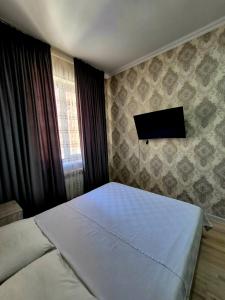 a bedroom with a bed and a flat screen tv at One-Bedroom Apartment in Fergana