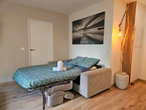 a bed and a couch in a room at Le splend'id à 10min de Disneyland in Chessy