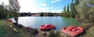 three boats sitting in the water on a lake at Ferme de L'Aoueille in Pouylebon