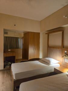 a hotel room with two beds and a fireplace at Atithi Palace in Bhāgalpur
