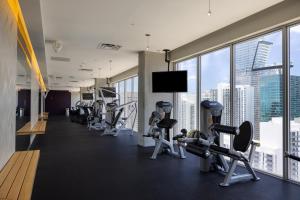 a gym with cardio equipment and a large window at High Floor Pool Gym Brickell in Miami