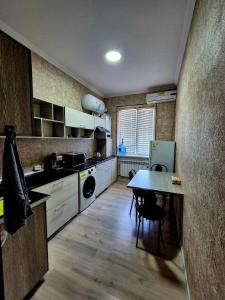 a kitchen with a table and a dining room at One-Bedroom Apartment in Fergana