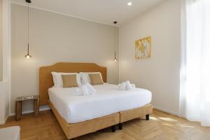 a bedroom with a large white bed with white sheets at Neris Boutique Rooms in Muggia +78 photos