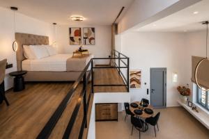 a room with a bed and a staircase leading to a bedroom at Tinian Sunset Suite in Istérnia