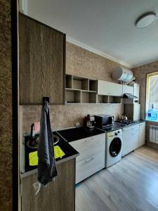 a kitchen with a sink and a dishwasher at One-Bedroom Apartment in Fergana +3 photos