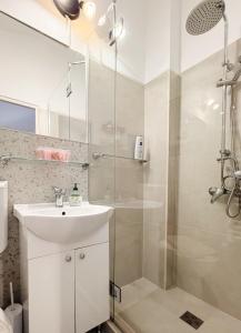 a white bathroom with a shower and a sink at Alandala by The Center in Cluj-Napoca