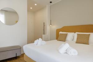 a bedroom with a large white bed and a mirror at Neris Boutique Rooms in Muggia