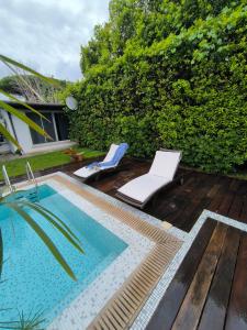 a swimming pool with two lounge chairs next to a hedge at Casa Lupita - Private Family Villa with Pool & Garden in Terracina