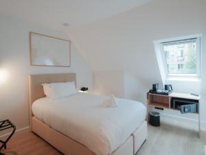 a bedroom with a large white bed and a window at City Pop 2Night Paris - Self check-in in Vanves +48 photos