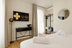 a hotel room with two beds and a desk at Neris Boutique Rooms in Muggia