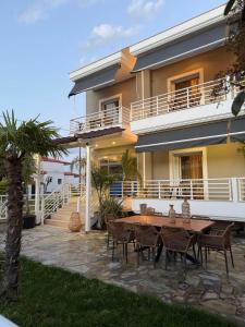 a table and chairs in front of a house at MG Luxury Living in Nea Vrasna