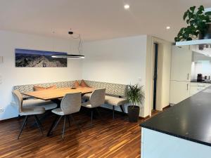 a kitchen and dining room with a wooden table and chairs at Ferienwohnung Hingucker in Tschagguns +6 photos