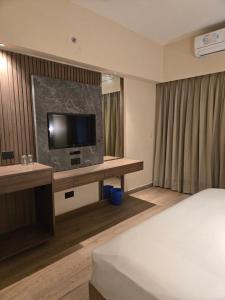 a hotel room with a bed and a flat screen tv at Atithi Palace in Bhāgalpur +18 photos