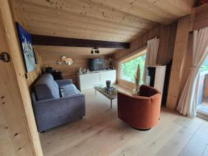 a living room with a couch and a table at Hôtel Le Labrador 1971 in Les Gets
