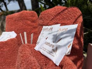 a pile of red towels with packets of kirmite fibre at La Cera Farm Camping B&B in Santa Teresa Gallura