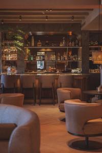 a restaurant with a bar with chairs and tables at Villa de Duinen - Adults Only in Noordwijk aan Zee