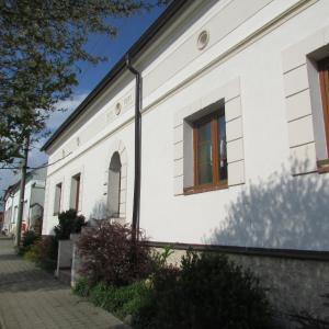 a white building with a window on the side of it at Privát u koní in Úherce
