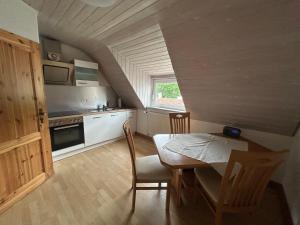 a kitchen with a table and a dining room at Wohnung an der schönen Aue Stadtzentrumsnähe in Fulda