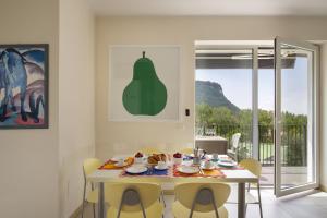a white dining room with a table and chairs at Cà Gardesana With Pool in Garda