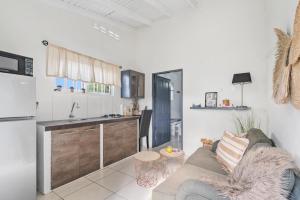 a living room with a couch and a kitchen at Mandavilla Apartment Curacao in Willemstad