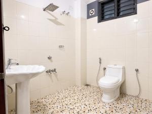 a bathroom with a toilet and a sink at Courtyard Residency Thekkady in Thekkady