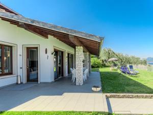 a house with a patio with chairs and an awning at Villa Manuela by Interhome in Brenzone sul Garda