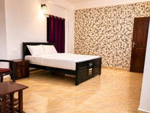 a bedroom with a bed and a wall at Courtyard Residency Thekkady in Thekkady