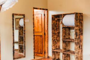 ein Zimmer mit zwei Spiegeln und einer offenen Tür in der Unterkunft Forest Sunset Hotel in Morogoro + 26 Fotos
