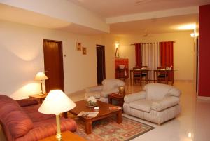 sala de estar con sofá, sillas y mesa en Sterling Living Space - Residency Road, en Bangalore