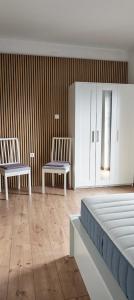 a room with two white chairs and a bed at Smit apartman in Novi Vinodolski