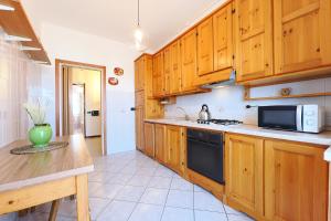 a kitchen with wooden cabinets and a stove top oven at PrimoPiano - Padova 256 in Milan