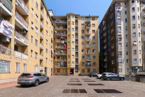 two cars parked in a parking lot in front of buildings at PrimoPiano - Padova 256 in Milan