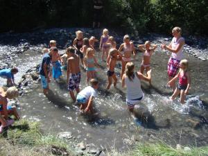 a group of people standing in the water in a river at Camping Lou Passavous in Le Vernet +1 photo