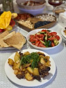 a table with plates of food on a table at Marjan Guest House in Bokonbayevo