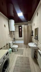 a bathroom with a toilet sink and a washing machine at Marjan Guest House in Bokonbayevo +19 photos