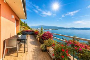 a balcony with flowers and a table and chairs at Open Space Mi Alma Lake View in Toscolano Maderno