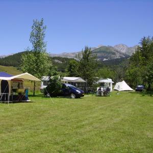 a group of tents and a car parked in a field at Camping Lou Passavous in Le Vernet