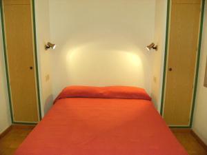 a small bedroom with a red bed in a room at Gran Sol C 01 in L'Escala