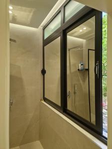 a bathroom with a glass shower with a window at Central Bazaar with Parking in Tirana +34 photos