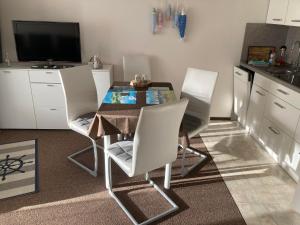 a kitchen with a table and chairs and a television at Kiek mol wedder in in Borkum