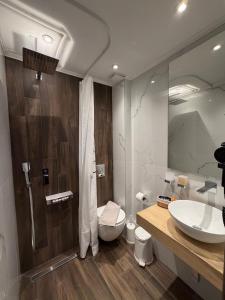 a bathroom with a sink and a toilet and a mirror at MG Luxury Living in Nea Vrasna +35 photos