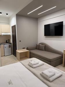 a living room with a couch and a flat screen tv at MG Luxury Living in Nea Vrasna