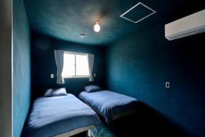 two beds in a blue room with a window at Suikomareso 2 水処稀荘 三隈川別館 in Hita +80 photos