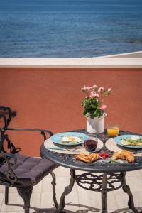 a table with plates of food and a vase of flowers at Villa Giada Luxury Boutique Hotel in Civitavecchia