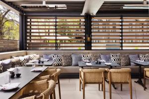a restaurant with tables and chairs and windows at White Elephant Aspen in Aspen
