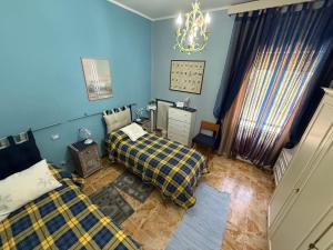 a bedroom with two beds and blue walls at Casa Della Nonna in Radicofani